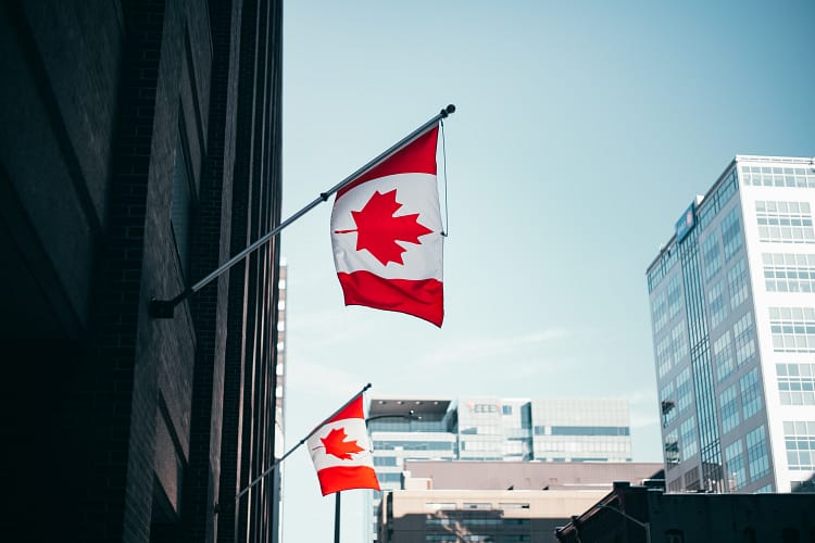 the Canadian flag hung out on the edge of a building representing the Canadian experience class